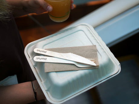 Home compostable bagasse takeaway clamshell container with a napkin and birchwood cutlery