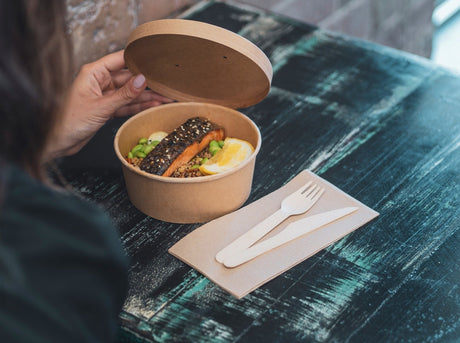 kraft paper takeaway container bowl with matching lid and wooden disposable cutlery and napkins
