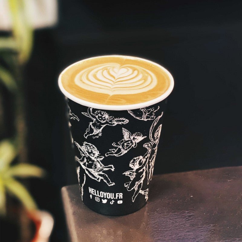 16oz custom printed single wall coffee cup containing a latte on a cafe table