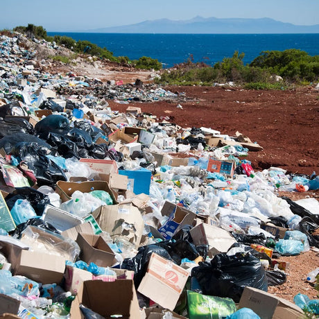 Industrial packaging waste littered all over a beach next to the coast 