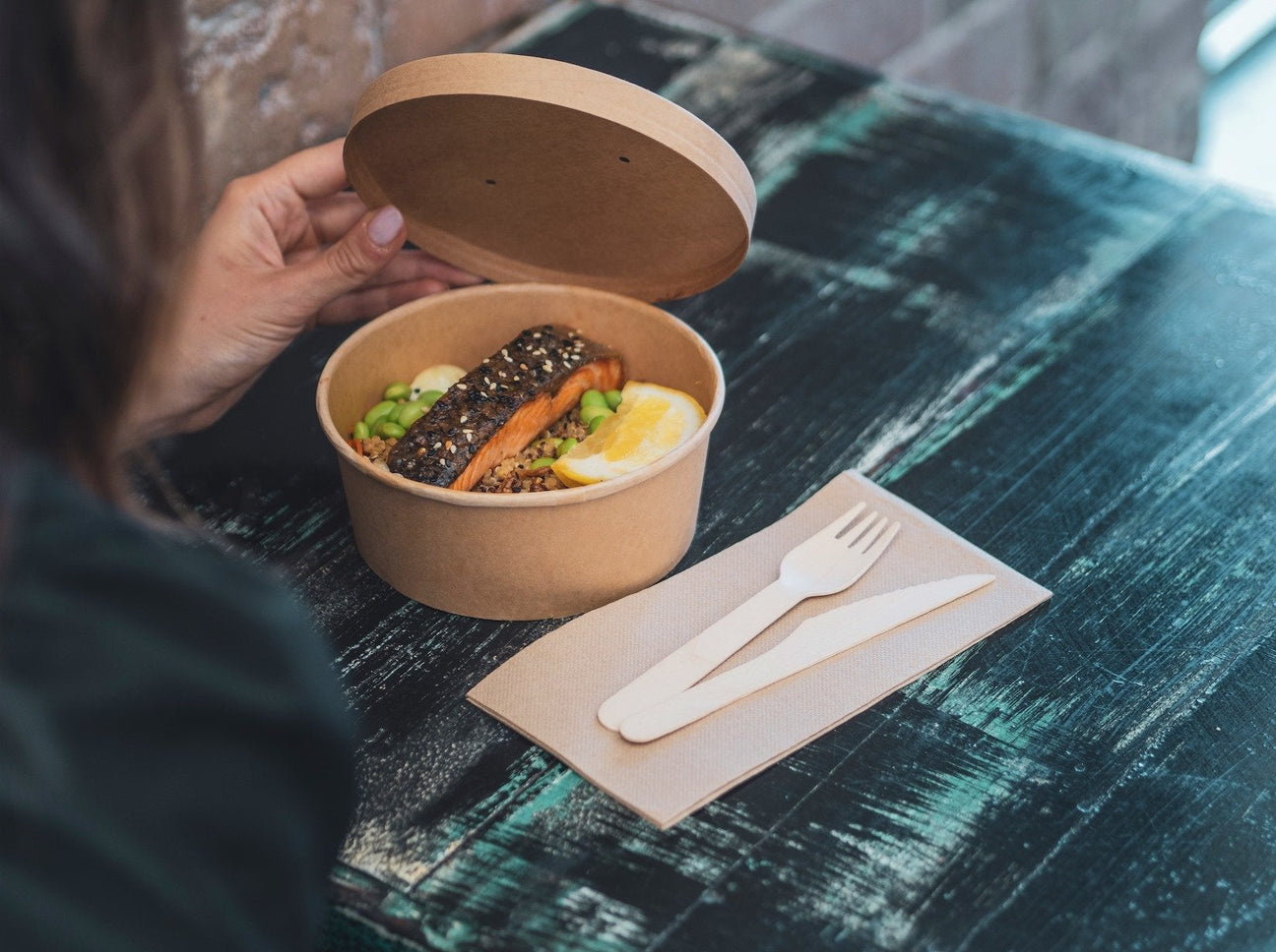 kraft paper bowl and wooden cutlery serving salmon to takeaway