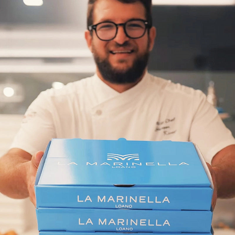 custom printed pizza boxes being held by a chef in a kitchen
